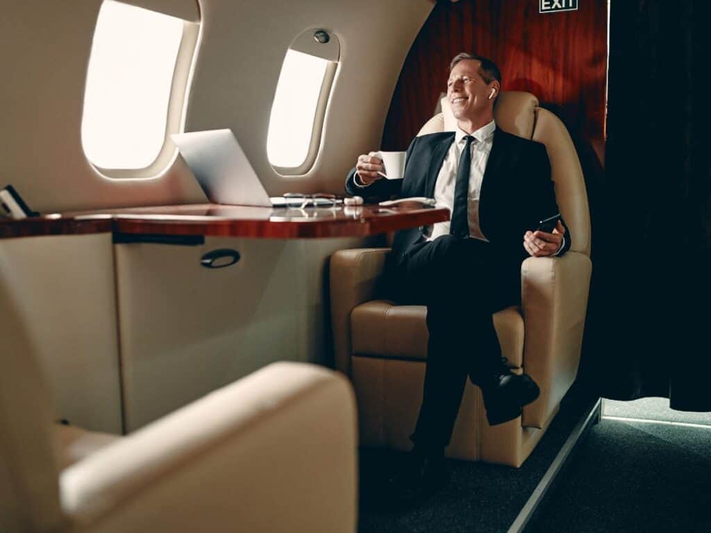 Executive businessman enjoying in-flight amenities on private jet.